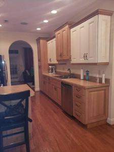 a kitchen with white cabinets and a wooden floor at Why Not enjoy while away! in Harrisonburg