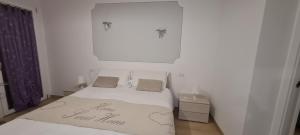Un dormitorio blanco con una cama con un feliz cartel de Año Nuevo. en Appartamento Belvedere 4, en Stresa
