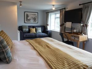 a bedroom with a bed and a couch at The Exeter Inn in Bampton