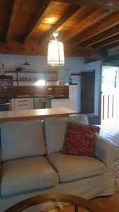 a living room with a couch and a kitchen at Casa Liron in Corao