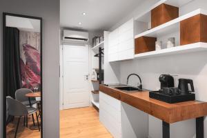 a kitchen with white cabinets and a sink at Residenze Chamur- Grattacielo in Palermo