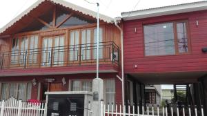 a red house with a fence in front of it at Polo Austral in Ushuaia