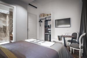 a bedroom with a bed and a table with a chair at Residenze Chamur- Grattacielo in Palermo