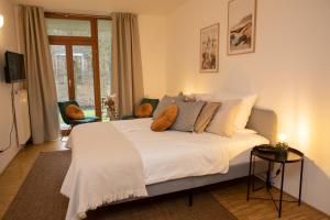 a bedroom with a large bed with pillows on it at Hotel Hofgut Imsbach Lapointe in Tholey