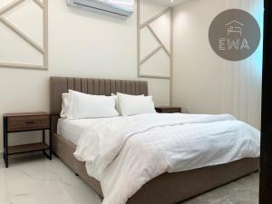 ein Schlafzimmer mit einem großen Bett mit weißer Bettwäsche und Kissen in der Unterkunft Kease Sulimania -5 Elegance Terrace GX91 in Riad