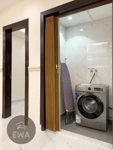 eine Waschmaschine in einem Zimmer mit Spiegel in der Unterkunft Kease Sulimania -5 Elegance Terrace GX91 in Riad