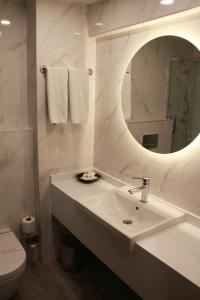 a white bathroom with a sink and a mirror at Hotel Buyuk Sahinler in Istanbul