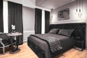a bedroom with a black bed and a table at Residenze Chamur- Grattacielo in Palermo