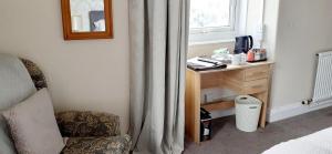 a bedroom with a desk and a chair and a window at Queens Rooms in Porthmadog