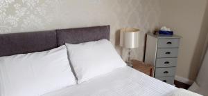 ポルスマドグにあるQueens Roomsのベッドルーム1室(白いベッド1台、ランプ、ドレッサー付)