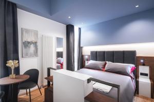 a bedroom with a bed and a table and a chair at Residenze Chamur- Grattacielo in Palermo