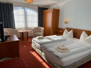 una habitación de hotel con una cama grande y una mesa en Hotel Seerose Bad Malente en Malente