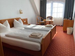 Una habitación de hotel con una cama con toallas. en Hotel Seerose Bad Malente en Malente