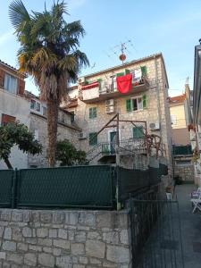 a building with a palm tree in front of it at Old stone house in historical area in Split