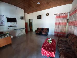 sala de estar con sofá y mesa en Lakwin guest wilpattu, en Nekattegama