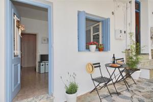 a room with a table and chairs and a window at Vanilla guesthouse in Skopelos Town