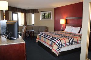 a hotel room with a bed and a flat screen tv at Apm Inn & Suites in Hagerstown