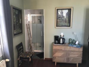 een kamer met een bureau, een dressoir en een spiegel bij La chambre de Toutou in Bastia