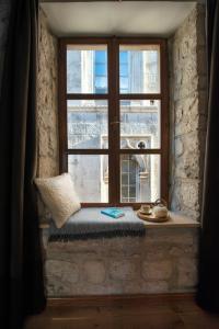 un sedile del finestrino con un cuscino davanti a una finestra di Loft in Ismaelli Palace Korcula a Korčula