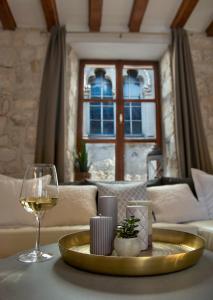 ein Wohnzimmer mit einem Tisch und einem Glas Wein in der Unterkunft Loft in Ismaelli Palace Korcula in Korčula