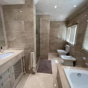 ein Badezimmer mit einem Waschbecken, einem WC und einer Badewanne in der Unterkunft Beautiful villa 2 steps from the BEACH in Marbella