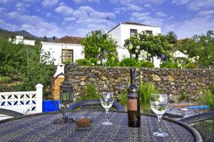 Una botella de vino sobre una mesa con dos copas. en Casa Tierras Viejas, en Tijarafe