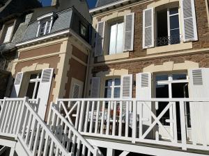 a house with a white fence and a balcony at Villa Hébert in Saint Malo