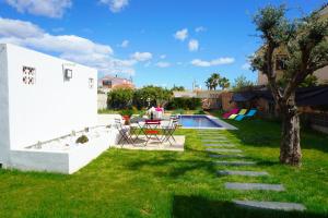 a backyard with a table and chairs and a pool at Villa Puerto Blanco in Vinarós