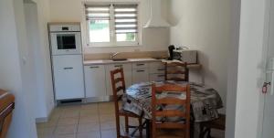 Bléneau的住宿－Gîte de la Haute Feuille，厨房配有桌椅和白色冰箱。