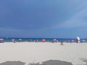 a group of people on a beach with umbrellas at Apartment in Trakia Plaza in Sunny Beach