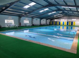 a large indoor swimming pool with blue water at Fabulous 2 bedroom dog friendly chalet 5 min walk to beach, nr Gt Yarmouth & Norfolk Broads in Scratby