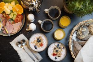 einen Tisch mit Teller mit Lebensmitteln und Schalen mit Früchten in der Unterkunft Hotel Söder in Stockholm