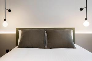 a bed with a white comforter and pillows at Leonardo Hotel Manchester Piccadilly in Manchester