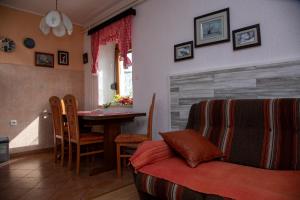 a living room with a couch and a dining room table at Apartman Žagar in Lokve