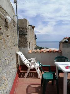 eine Terrasse mit einem Tisch, Stühlen und Meerblick in der Unterkunft La Casa dell'Elleboro in Giustenice
