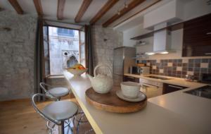 a kitchen with a counter with cups and stools at Loft in Ismaelli Palace Korcula in Korčula