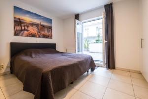 a bedroom with a bed with a painting on the wall at Appartement GT in Blankenberge