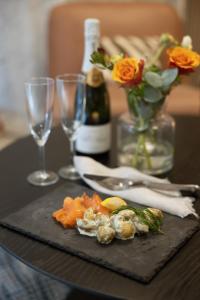 een tafel met een bord eten en een fles wijn bij Hotel Söder in Stockholm