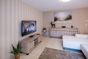 a living room with a couch and a flat screen tv at Appartement GT in Blankenberge