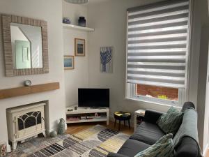 a living room with a couch and a fireplace at Beresford81 in Cowes