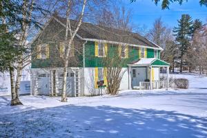 a green and white house with a snow covered yard at Mayville Getaway - Walk to Chautauqua Lake! in Mayville