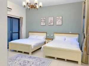 Duas camas sentadas uma ao lado da outra num quarto em The Awesome Manor em Jian