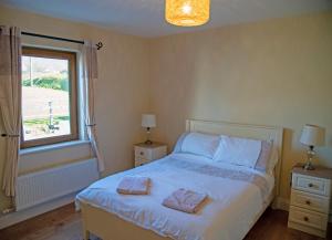 a bedroom with a bed with two towels on it at Malachys Rest Dingle in Dingle