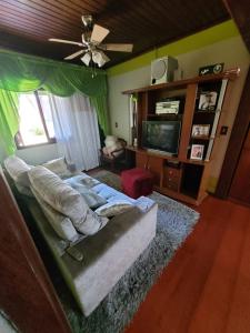 uma sala de estar com um sofá e uma televisão em Espaço Doméstico em Caxias do Sul