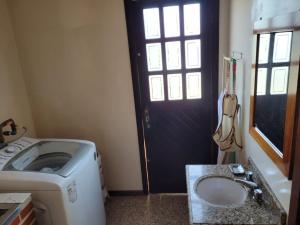 uma casa de banho com uma máquina de lavar roupa e uma porta em Espaço Doméstico em Caxias do Sul