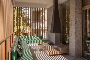 un balcone con mobili verdi e bianchi in un edificio di Bio Boutique Hotel XU' - Gruppo Ambienthotels a Rimini