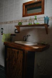 a bathroom with a sink and a mirror at Cabañas Kairós in El Bolsón