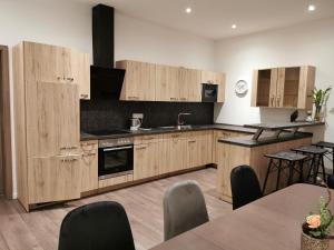 a kitchen with wooden cabinets and a table and chairs at Amys Ferienwohnungen Bad Harzburg in Bad Harzburg