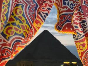 una vista de las pirámides de Giza desde debajo de una cortina en Pyramids top success result, en El Cairo