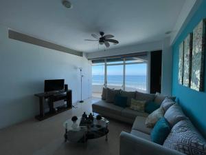 マサトランにあるDepartamento en Torre Miramar, Malecón de Mazatlánのソファとテーブルのあるリビングルーム